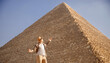 Man tourist with hat and bag walks background of pyramids in Giza Cairo Egypt, sun light travel