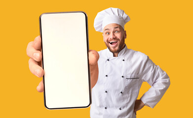 Happy chef man showing smartphone with white blank screen, recommending catering service or food delivery app
