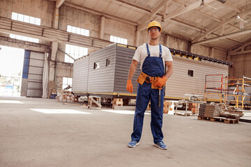 Wall Mural - Male worker standing inside building with construction cabin