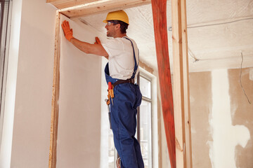 Wall Mural - Male worker hanging wallpaper on the wall