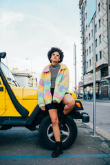 Stylish confident black curly hair woman posing outdoor