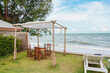 © Mumemories - Wooden gazebo and sun lounger on green lawn in tropical sea