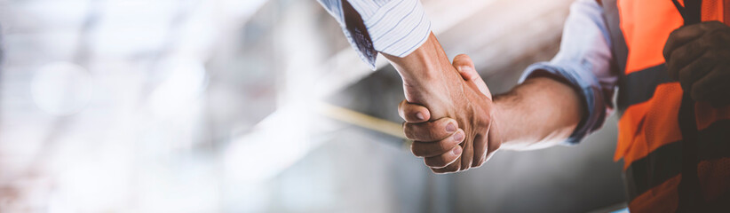 Two engineer shaking hands with deals and congratulations on success, panorama image use for cover design.