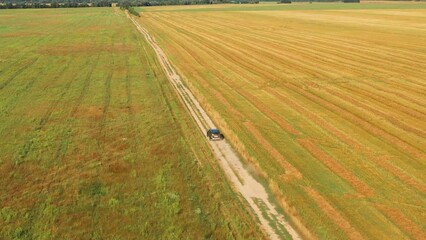 Wall Mural - Car Elevated View Of SUV Car Vehicle Automobile SUV In Drive Motion On Countryside Road Through Summer Green Fields. Agricultural Country Rural Landscape. Car Drive In Motion.