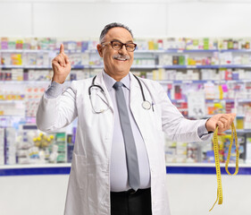 Poster - Mature male holding a measuring tape in a pharmacy