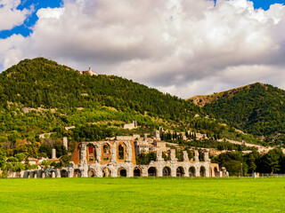 Gubbio, ancient ruins of the roman amphitheater with the medieval village in background, Umbria region, central Italy

