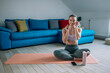 © Zamrznuti tonovi - Woman using airpods and a smartphone while training at home
