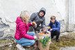 © weyo - Man, woman and teenage boy share bread from a package of humanitarian aid that arrived in Ukraine