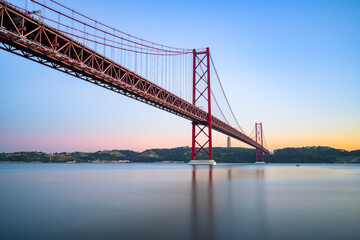 Sticker - The 25 de Abril bridge at sunset over the Tajo River in Lisbon. Portugal