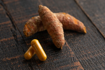 Wall Mural - Ground Turmeric Capsules form on a Wooden Table