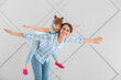 © Pixel-Shot - Portrait of happy mother and daughter on grey background
