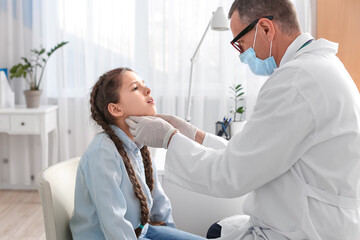 Poster - Doctor examining little girl's neck in clinic