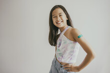 Mixed Asian Preteen Girl Showing Her Arm With Bandage After Got Vaccinated Or Inoculation, Child Immunization, Covid Omicron Vaccine Concept