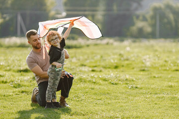 Father and son playing with a kite on summer outdoors