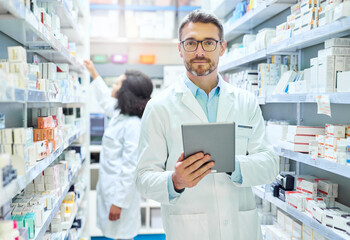 Poster - Its a pharmacists best friend. Shot of a mature man using a digital tablet to do inventory in a pharmacy.