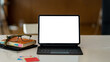 © amnaj - Tablet blank screen on desk and workspace background in modern office.