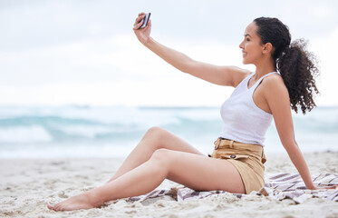 Canvas Print - Cant forget the beach selfie. Shot of a young woman taking a selfie at the beach.