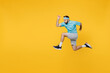 © ViDi Studio - Full body side view strong young fitness trainer instructor sporty man sportsman wear headband blue t-shirt jump high run fast isolated on plain yellow background. Workout sport motivation concept