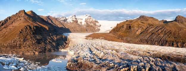 Wall Mural - high angle drone shot of the svinafellsjokull glacier, mountains and glacial lagoon. wide autumn pan