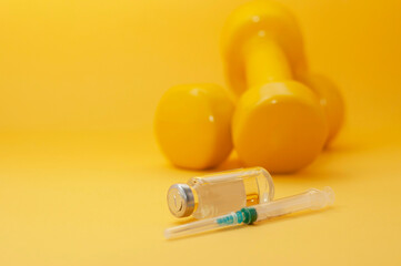 Poster - syringe and a jar of liquid lie in front of the dumbbells on a yellow background, copy space, close-up. the concept of doping in sports, steroids, testosterone and other drugs banned in sports.