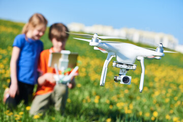 Wall Mural - children operating of flying drone at field