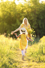 Mother And Little Daughter Having Fun In Summer Meadow With Yellow Flowers. Happy Family On Summer. Concept Of Healthy Family Without Allergies. High Quality Photo