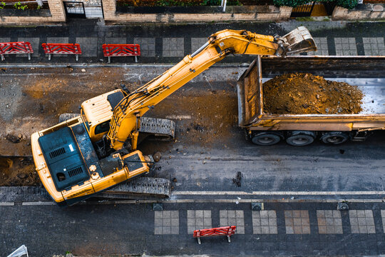 construction equipment excavates a city street to improve the wastewater infrastructure. Top View. Selective Focus Machine