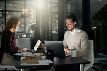 Canvas Print - If you can dream it, he can design it. Shot of two young designers working late in the office.