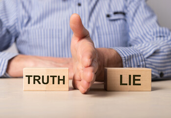 man divides blocks with words truth and lie. confrontation between true and false information, news,