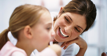 Wall Mural - Making sure her smile is as bright as her future. Shot of a beautiful young mother watching her daughter brush her teeth in the bathroom at home.