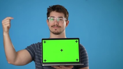 Wall Mural - Young smiling happy man 20s wear striped t-shirt use work on laptop pc computer with tracking points green screen, browsing chatting with blank screen workspace area isolated on solid blue background