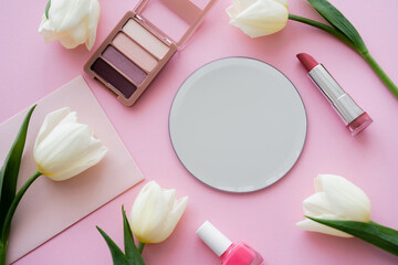 Canvas Print - top view of white tulips on envelope near decorative cosmetics on pink.