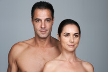We Look Good For Our Age. Studio Portrait Of A Mature Man And Woman Standing Close Together Against A Gray Background.