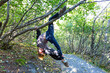© Todd - An athletic young woman hangs from a tree branch, during a hike to Exit Glacier, just outside of Seward, Alaska.  Summer.