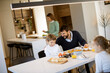 © BGStock72 - Young happy family talking while having breakfast at dining table