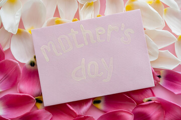 Wall Mural - top view of envelope with mothers day lettering on white and pink floral petals.