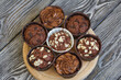 Chocolate muffins with different fillings. On black pine boards. Shot close-up.