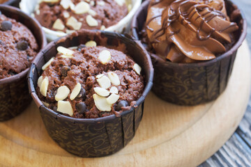 Wall Mural - Chocolate muffins with different fillings. On pine boards. Shot close-up.