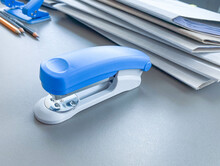 Photo of blue stapler put on the table in office, stapler is a device used in schools or offices