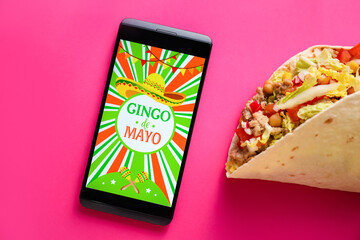 Traditional Mexican tacos and mobile phone on color background. Cinco de Mayo (Fifth of May) celebration