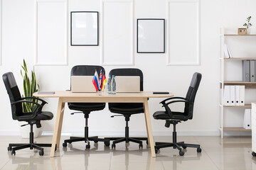 Wall Mural - Interior of modern meeting room with laptops and flags on table