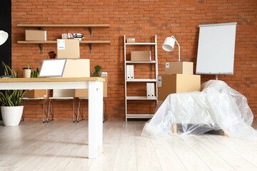 Wall Mural - Cardboard boxes with belongings and furniture in interior of office on moving day