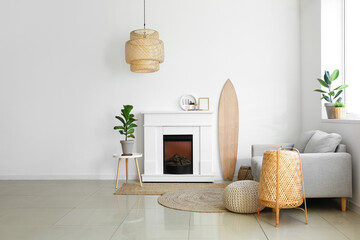 Interior of light living room with wooden surfboard and fireplace