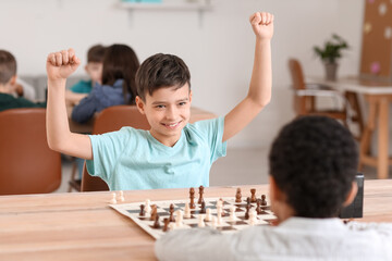 Wall Mural - Little children playing chess during tournament in club