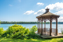 A Wood Gazebo Over Looks The Niagara River In Niagara On The Lake, Ontario, Canada On A Blue Sky Day. The United States Can Be Seen In The Distance.