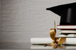 © artrolopzimages - Birrete con libros apilados y diploma al lado. Concepto de graduación.