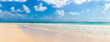 Banner of a large empty sandy beach and a clean warm sea and blue sky with few clouds as a symbol of an iconic summer holiday destination