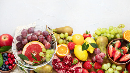 Wall Mural - Assortment of colorful ripe tropical fruits on light gray background.