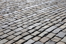 Stone Pavement Texture, Cobbled Street In Sunlight. Old Paved Road With Tiles From Cobblestones