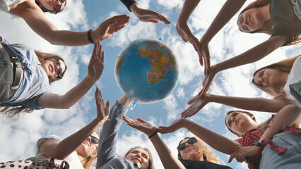 Wall Mural - Earth conservation concept. 11 girls surround the rotating earth globe with their palms hands.